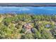 Stunning aerial view of a lakeside estate with lush greenery, featuring a Mediterranean-style house with a terracotta roof at 2111 Hontoon Rd, Deland, FL 32720