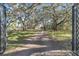 Long brick driveway leading to a stately home, framed by mature trees with Spanish moss draping from the branches at 2111 Hontoon Rd, Deland, FL 32720
