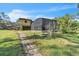 Back exterior view of the house showcasing the screened in pool area and luscious backyard at 2111 Hontoon Rd, Deland, FL 32720