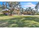 Spacious home with a circular driveway, porte cochere, and a detached garage, surrounded by a well-manicured lawn at 2111 Hontoon Rd, Deland, FL 32720