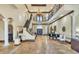 Grand foyer with a soaring ceiling, elegant staircase, travertine floor, and exquisite chandelier at 2111 Hontoon Rd, Deland, FL 32720