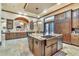 Gourmet kitchen with custom cabinets, granite island, copper sink, stainless steel appliances, and stone backsplash at 2111 Hontoon Rd, Deland, FL 32720