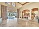 Grand living room with soaring ceilings, tile floors, and elegant columns overlooking the pool at 2111 Hontoon Rd, Deland, FL 32720