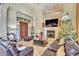 Living room with a stone fireplace, leather couches, tall ceilings, and access to front of home at 2111 Hontoon Rd, Deland, FL 32720
