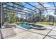 Enclosed pool area with travertine tile, featuring an adjacent spa and lounge chairs for relaxation at 2111 Hontoon Rd, Deland, FL 32720