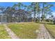 Screened in pool with a serene backyard surrounded by trees at 2111 Hontoon Rd, Deland, FL 32720