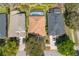 Bird's eye view displaying uniform rooftops of homes in a neighborhood with driveways, cars, and lush trees at 215 Coleton Ln, Deland, FL 32724