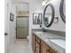 Bathroom featuring double sinks with granite countertop, wood cabinets, and tiled shower at 215 Coleton Ln, Deland, FL 32724