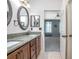 Bathroom featuring double sinks, wood cabinets, granite countertop, and walk-in shower at 215 Coleton Ln, Deland, FL 32724