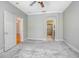Neutral bedroom featuring plush carpet, ceiling fan, and open bathroom and closet at 215 Coleton Ln, Deland, FL 32724
