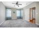 Spacious bedroom with carpet flooring, a ceiling fan, and light blue curtains at 215 Coleton Ln, Deland, FL 32724