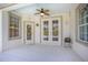 Enclosed patio with a ceiling fan, windows, and glass patio doors leading to the backyard at 215 Coleton Ln, Deland, FL 32724