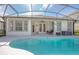 Back of house showing an enclosed patio with outdoor furniture and a large inviting pool at 215 Coleton Ln, Deland, FL 32724