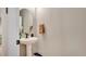 Cozy half bathroom featuring a pedestal sink, round mirror and neutral color palette at 221 Aston Grande Dr, Daytona Beach, FL 32124