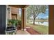Relaxing covered patio with a grill, lush greenery, and a tranquil lake view, perfect for outdoor enjoyment at 221 Aston Grande Dr, Daytona Beach, FL 32124
