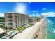 Stunning aerial view showcasing the condo building, pool, beach access, and the expansive ocean at 2403 S Atlantic Ave # 209, Daytona Beach Shores, FL 32118