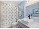 Bright bathroom features a stylish vanity, vessel sink, and a shower with a decorative shower curtain at 2403 S Atlantic Ave # 209, Daytona Beach Shores, FL 32118