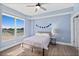 Bright bedroom with a large window, simple decor, and hardwood floors at 2403 S Atlantic Ave # 209, Daytona Beach Shores, FL 32118