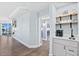 Hallway with wood flooring and a coffee bar area featuring white cabinets and an overhead shelf at 2403 S Atlantic Ave # 209, Daytona Beach Shores, FL 32118