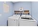 The laundry room features a modern washer and dryer set, complemented by decor and shelving at 2403 S Atlantic Ave # 209, Daytona Beach Shores, FL 32118