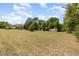 Extensive backyard showcasing open lawn space, mature trees, and outbuildings, ideal for outdoor activities and storage at 2485 Se 159Th Lane Rd, Summerfield, FL 34491