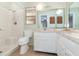 Bathroom with white vanity, a large mirror, and a shower/tub combo with white tile surround at 2485 Se 159Th Lane Rd, Summerfield, FL 34491