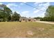 A charming single-story house with a large front yard and mature trees, creating a serene and inviting outdoor space at 2485 Se 159Th Lane Rd, Summerfield, FL 34491