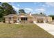 Inviting single-story home with stone accents, a covered carport, and a well-maintained yard, offering a cozy curb appeal at 2485 Se 159Th Lane Rd, Summerfield, FL 34491