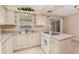 Well-lit kitchen with ample cabinetry, a cooktop, and a view to the outdoors, providing a functional and pleasant cooking space at 2485 Se 159Th Lane Rd, Summerfield, FL 34491