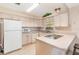 Cozy kitchen with white cabinetry, a built-in cooktop, and ample counter space, ideal for cooking and meal preparation at 2485 Se 159Th Lane Rd, Summerfield, FL 34491
