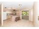 Bright eat-in kitchen featuring white appliances, a breakfast bar, and sliding glass doors to the outdoor patio, perfect for dining at 2485 Se 159Th Lane Rd, Summerfield, FL 34491