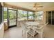 Screened porch with a tile floor, a ceiling fan, and a table and chairs overlooking the backyard at 2485 Se 159Th Lane Rd, Summerfield, FL 34491