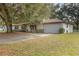 Exterior view of home featuring driveway, large shade tree and brick facade at 270 Sandyhook Ln, Deland, FL 32724