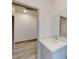 Bathroom featuring a gray vanity with quartz countertop, a mirror, and an open doorway to a room with light wood flooring at 28 Guava Ln, Ocklawaha, FL 32179