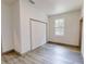 Bedroom features light gray wood-look flooring, neutral paint, window, and a closet at 28 Guava Ln, Ocklawaha, FL 32179