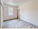 Bright, airy bedroom with light gray wood-look flooring, large window, and neutral paint at 28 Guava Ln, Ocklawaha, FL 32179