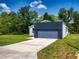 View of the two-car garage, long driveway and front lawn at 28 Guava Ln, Ocklawaha, FL 32179