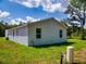 Rear of the property with manicured lawn and windows at 28 Guava Ln, Ocklawaha, FL 32179