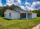 View of the home's exterior with a covered patio, freshly cut grass, and a bright white exterior at 28 Guava Ln, Ocklawaha, FL 32179