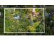Expansive aerial view of a lush property featuring mature trees, two houses, and a refreshing swimming pool at 2910 Hardy Ave, New Smyrna Beach, FL 32168