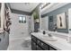 A full bathroom with a white sink, dark vanity, and patterned tile at 2910 Hardy Ave, New Smyrna Beach, FL 32168