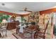 Dining room features a stone fireplace, traditional furnishings, wood floors, and a ceiling fan at 2910 Hardy Ave, New Smyrna Beach, FL 32168