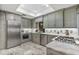 A modern kitchen featuring granite countertops, stainless steel appliances, and designer fixtures and cabinets at 2910 Hardy Ave, New Smyrna Beach, FL 32168