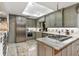 Bright kitchen features gray cabinets, stainless steel appliances, gas cooktop and stone countertops at 2910 Hardy Ave, New Smyrna Beach, FL 32168