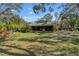 A sprawling home with a cozy screened in porch surrounded by lush green grass and beautiful trees at 2918 Hardy Ave, New Smyrna Beach, FL 32168