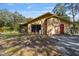 Home with a wood exterior, red front door, screened in patio, and a lush green front yard at 2918 Hardy Ave, New Smyrna Beach, FL 32168