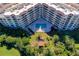 Aerial shot of the condo complex with a serene pool area and lush landscaping, offering a tranquil escape at 3 Oceans West Blvd # 1D6, Daytona Beach Shores, FL 32118