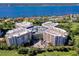Aerial view of luxury condo building with a round central garage, water views and lush landscaping at 3 Oceans West Blvd # 1D6, Daytona Beach Shores, FL 32118