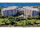 Aerial view of luxury condo building with a round central garage, water views and lush landscaping at 3 Oceans West Blvd # 1D6, Daytona Beach Shores, FL 32118