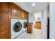 Convenient laundry room featuring wooden cabinets, granite countertops, and in-unit washer and dryer at 3 Oceans West Blvd # 1D6, Daytona Beach Shores, FL 32118